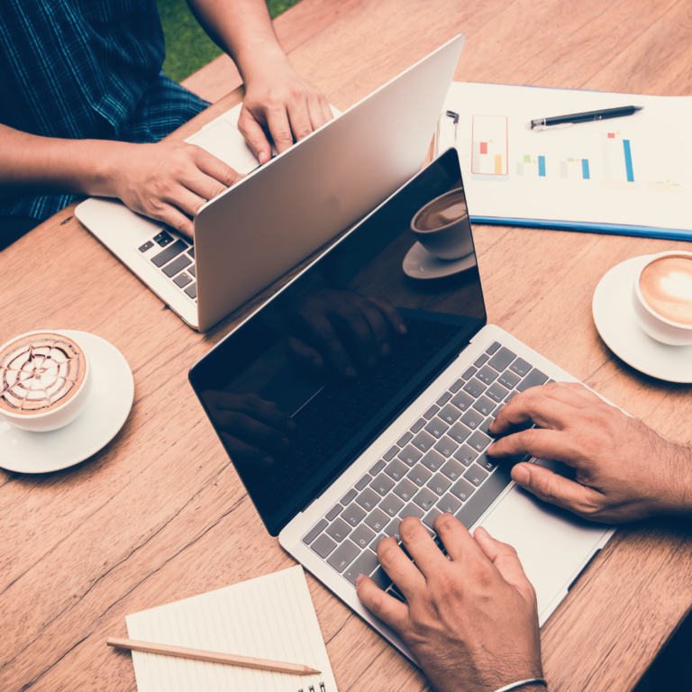 two people on laptops with lattes on the table